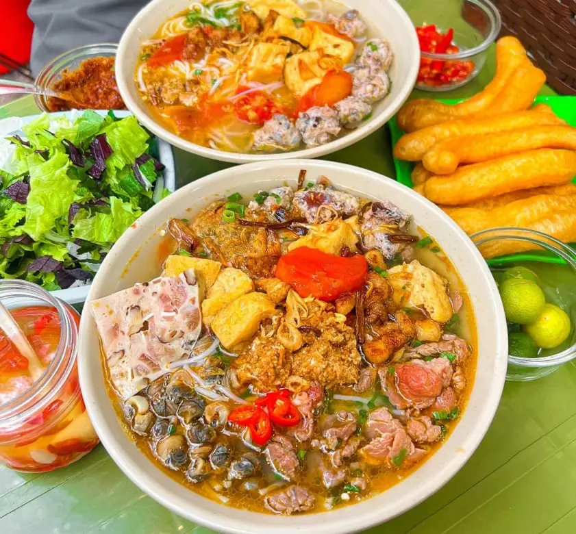 Bún riêu ốc đầy đủ topping hấp dẫn.