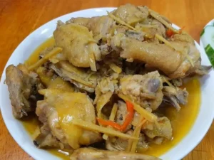 Gà kho gừng vàng nâu rắc tiêu hành lá.