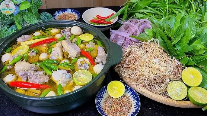 Lẩu gà chanh ớt bốc khói, rau ăn kèm.